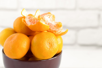Fresh tangerines in a bowl on a light background