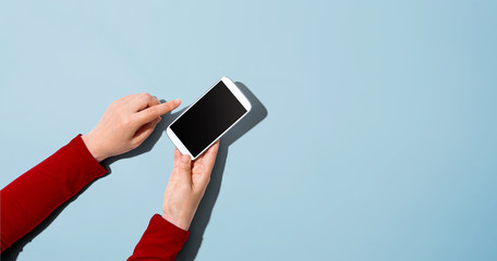 Obraz na płótnie Canvas Person using a white smartphone - overhead view