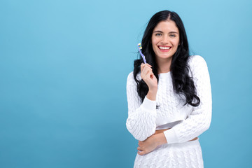 Young woman holding a toothbrush on a blue background