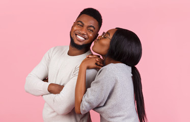 Happy african woman kissing her smiling man