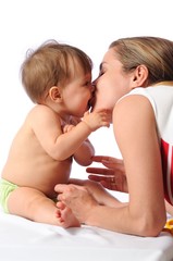 Obraz na płótnie Canvas Mother kisses little baby girl