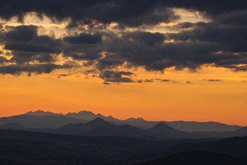 A mountain silhouette in the evening on a background of red sky