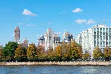 Fototapeta na wymiar Skyline of Roosevelt Island with the Upper East Side of Manhattan in New York City in the background with Colorful Trees during Autumn