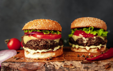 two Tasty grilled burgers on a stone background