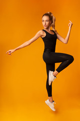 Fit Lady Jumping During Workout Over Yellow Background