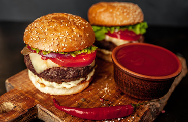 two Tasty grilled burgers on a stone background