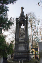 Fototapeta premium Monument and candles in the cemetery. All Saints Day in Poland. Stone crypt in the cemetery.