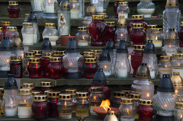 Monument and candles in the cemetery. All Saints Day in Poland. A lot of funeral candles.