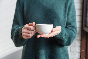Tea cup in women's hand close up