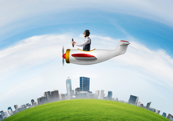 Businessman in leather helmet flying in plane