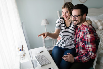 Young couple of designers working on computer