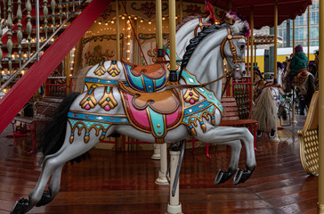 Carousel with horses. Ornate painted white toy horse of vintage carousel in French style. Retro...