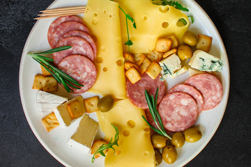 cheese board (different types of cheese plate appetizers , sausage, ham, olives, greens and more) menu concept. food background. copy space. Top view