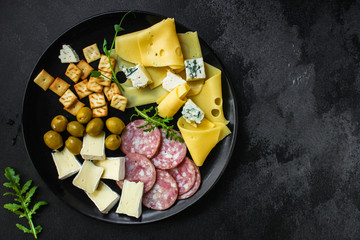 cheese board (different types of cheese plate appetizers , sausage, ham, olives, greens and more) menu concept. food background. copy space. Top view