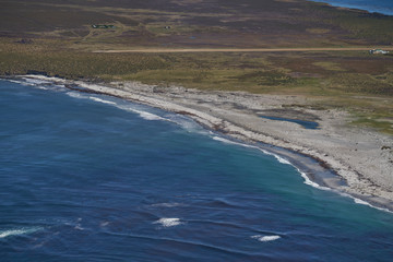 View from an aircraft flying over beautiful white sandy beaches and clear blue waters of Sea Lion Island in the Falkland Islands.