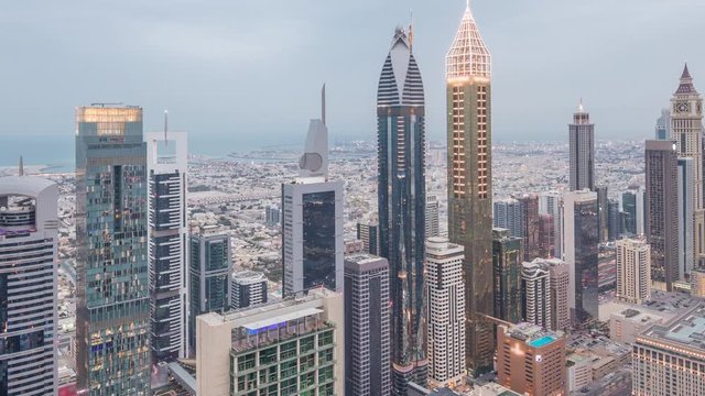 Skyline of the buildings near Sheikh Zayed Road and DIFC aerial day to night transition timelapse in Dubai, UAE. Modern towers and skyscrapers in financial center and downtown after sunset
