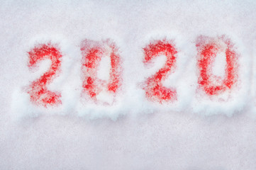  red numbers of the new year two thousand twentieth painted on white snow top view