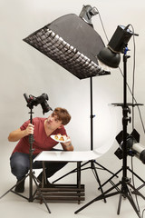 Male photographer in studio shooting food on plate