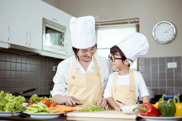Happy family Asian woman young mother with son boy cooking healthy salad for the first time. first lesson and healthy lifestyle concept.