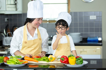 Happy family Asian woman young mother with son boy cooking healthy salad for the first time. first lesson and healthy lifestyle concept.