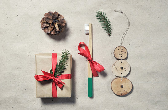 Zero waste plastic free christmas gift flatlay. Bamboo toothbrush, gift box wrap in craft paper, handmade xmas natural decoration. Concept of mindful consumption. Eco-friendly lifestyle.