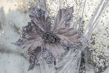 Silver flower on ice background with icicles, Christmas winter bouquet, Christmas composition, selective focus