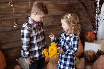 Fototapeta premium boy and girl play with bouquet of yellow flowers.