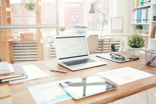 Background Image Of Modern Office Interior With Laptop On Wooden Table, Workplace Design Concept, Copy Space