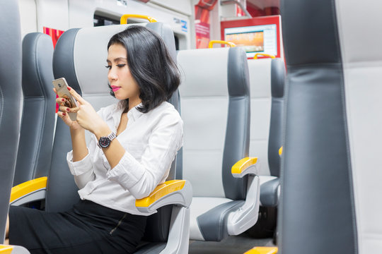 Asian businesswoman send text messages on the train