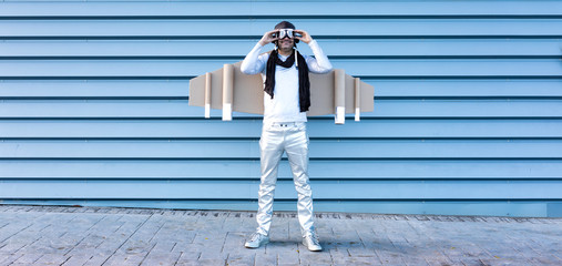 man in silver suit with glasses and aviator helmet and cardboard plane wings © Sergio