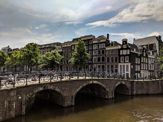 View of Amsterdam canals with bridge and typical dutch houses. Holland