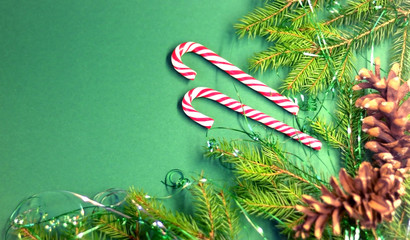  Christmas card with spruce and holiday decorations, sweets, on a green background. Christmas template for banner, ticket, brochure, card, invitation, poster, etc. Place for text.