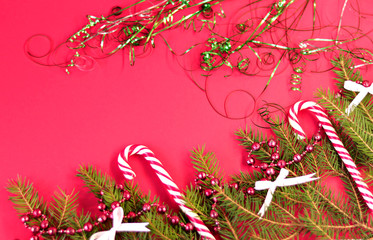 Christmas card with spruce and holiday decorations, sweets, on a red background. Christmas template for banner, ticket, brochure, card, invitation, poster, etc. Place for text.