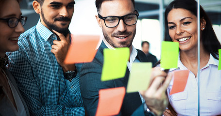 Businesswoman using sticky notes at office to plan project