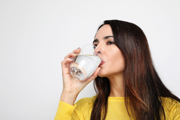 Close-up portrait of young woman drinking water. Healthy concept. Isolated.