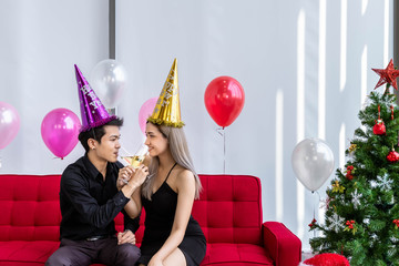 Attractive young couple celebrate Christmas and New Year together, drinking champagne