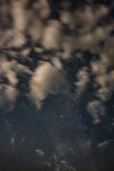 The milky way in the night sky through the clouds