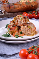 Roasted cabbage rolls with meat served on a white plate with sour cream. Russian cuisine meal 