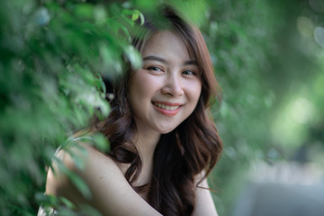 Portrait of smiling beautiful asian women in park morning light with bokeh