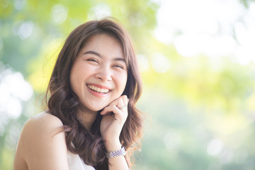 Portrait of smiling beautiful asian women in park morning light with bokeh