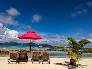 Two sunbeds under bright red umbrella