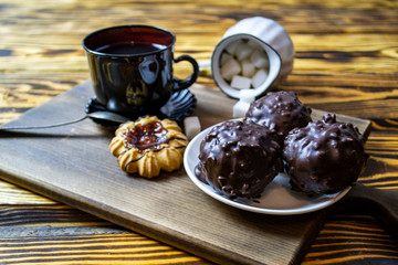 cup with tea near sugar bowl with tea and cookies