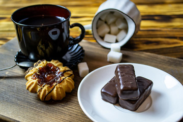 cup with tea near sugar bowl with tea and cookies