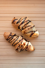Tasty chocolate croissants on wooden background