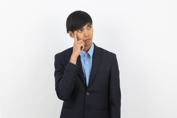 Young handsome asian business man thinking an idea while looking up isolated on white background.
