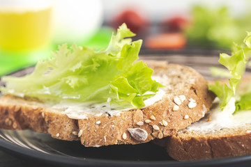 Sandwich with green lettuce on cereal bread.