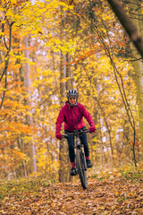 Obraz premium nice senior woman riding her mountainbike on the autumnal forest trails near Stuttgart, beautiful warm colors