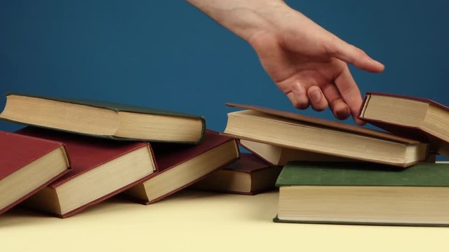 a man collects books scattered on the table