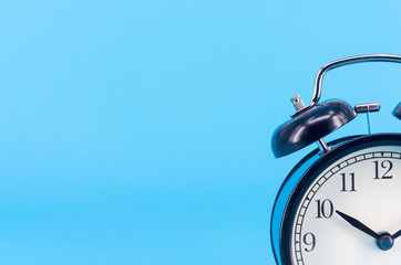 Alarm clock on blue background. Selective focus.