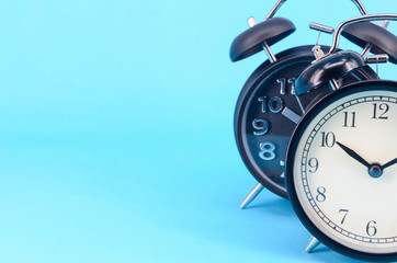 Alarm clock on blue background. Selective focus.